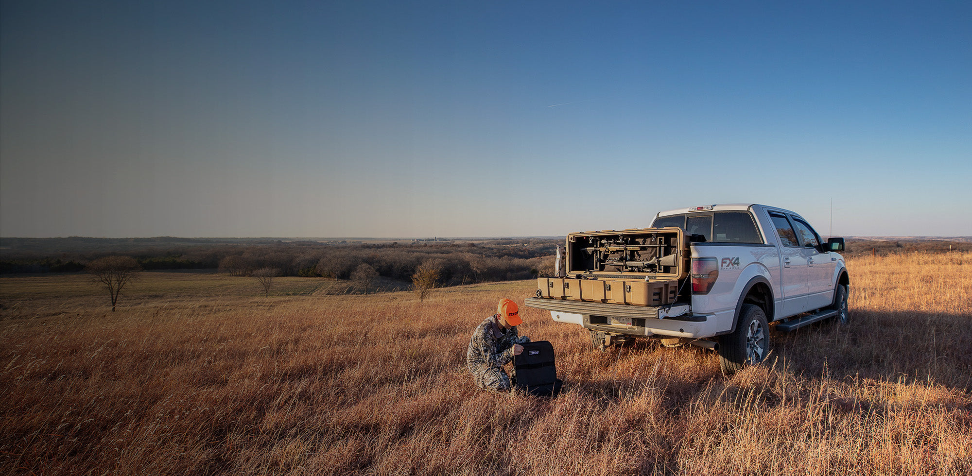 Bronc 52 on Truck Bed in a Grassy Field Outdoors Before Going Out on a Hunt